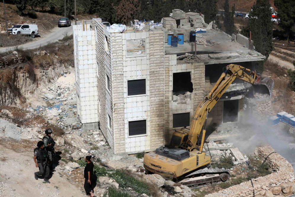 Israeli border police stand guard as Israeli bulldozers demolish a Palestinian house in Hegrah Village in the West Bank, South Hebron, on September 25, 2019.