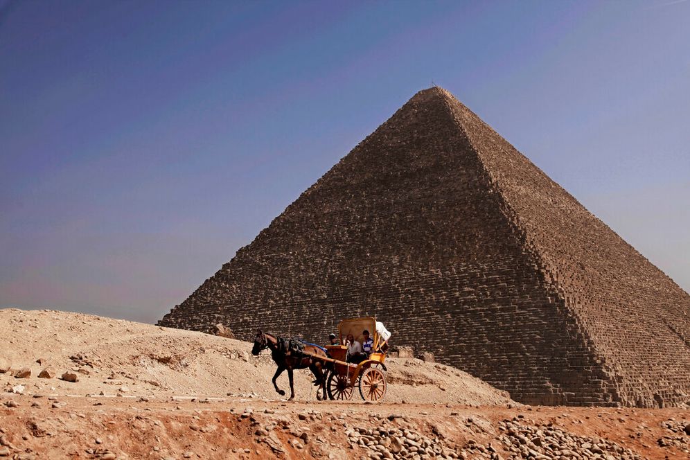(AP Photo/Nariman El-Mofty) مصريون يركبون عربة أمام هرم خوفو، في الخلفية، بالقرب من القاهرة، مصر