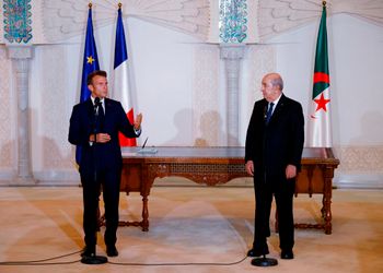 الرئيس الفرنسي إيمانويل ماكرون، يتحدث بينما يستمع الرئيس الجزائري عبد المجيد تبون خلال حفل توقيع في مطار الجزائر العاصمة ، السبت 27 أغسطس 2022.