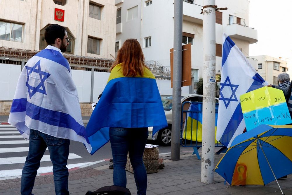 Des manifestants en soutien à l'Ukraine enveloppés dans des drapeaux israélien et ukrainien à Tel-Aviv, le 24 février 2022