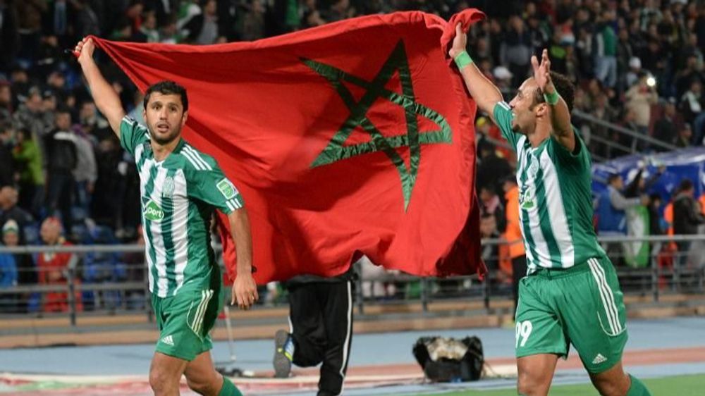 Morocco Raja Casablanca's players hold their national flag as they celebrate in Marrakesh on December 18, 2013