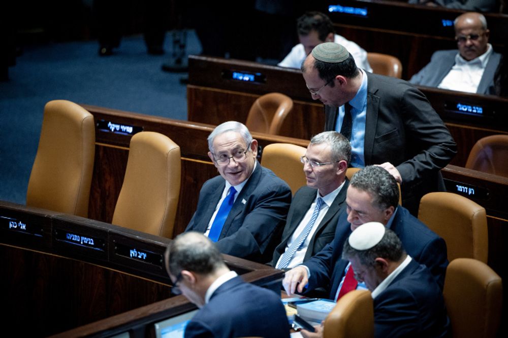 Israeli Prime Minister Benjamin Netanyahu (L), Justice Minister Yariv Levin, other senior ministers and coalition lawmakers at the Knesset plenum vote.