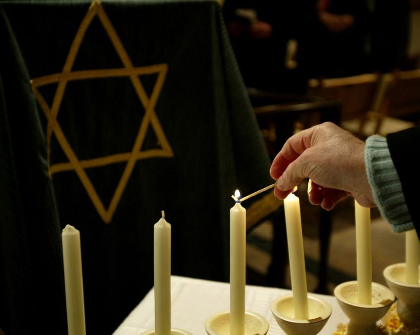 Uma mulher acende uma vela durante uma cerimônia em 26 de janeiro de 2006, na véspera do dia em memória do Holocausto.
