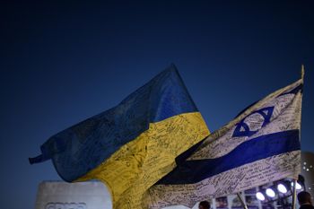 People carry flags during a protest against the Russian invasion of Ukraine, in Tel Aviv, Israel.