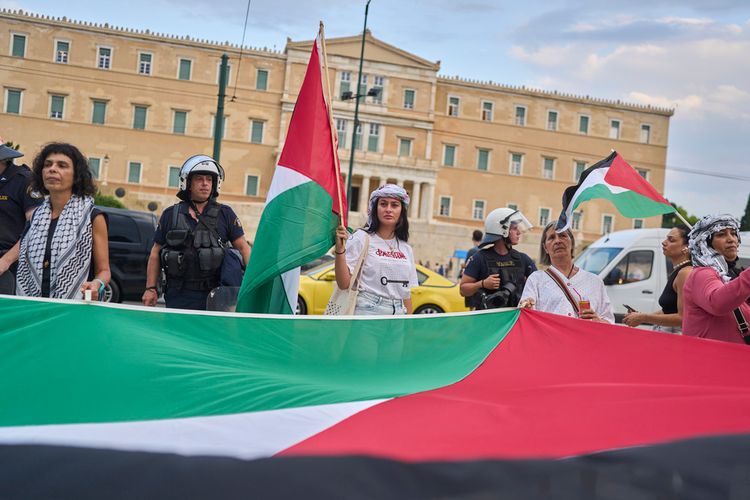 A protester waves Palestinian flags during a demonstration against the war in the Gaza Strip and Israel's measures regarding food distribution, outside Greece's Parliament in central Athens, Thursday, July 31, 2025