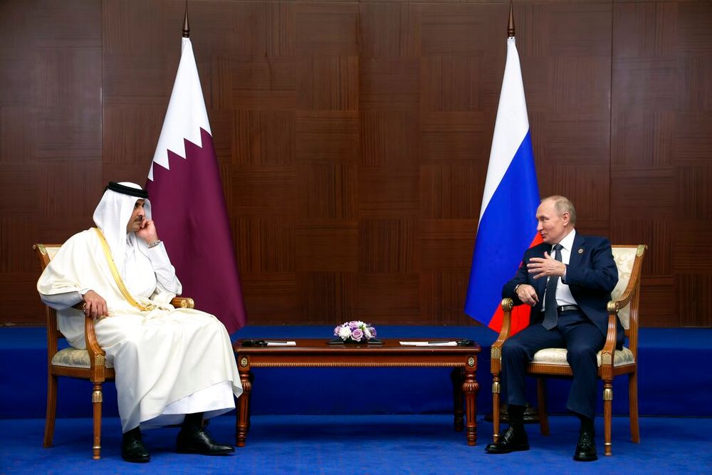 Russian President Vladimir Putin (R) gestures while speaking to the Emir of Qatar, Sheikh Tamim bin Hamad Al Thani, in Astana, Kazakhstan, on October 13, 2022.