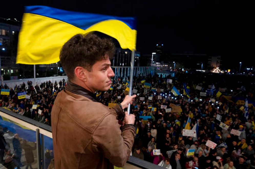 A man waves a representation of the Ukrainian flag overlooking Habima Square in Tel Aviv, Israel, February 26, 2022.