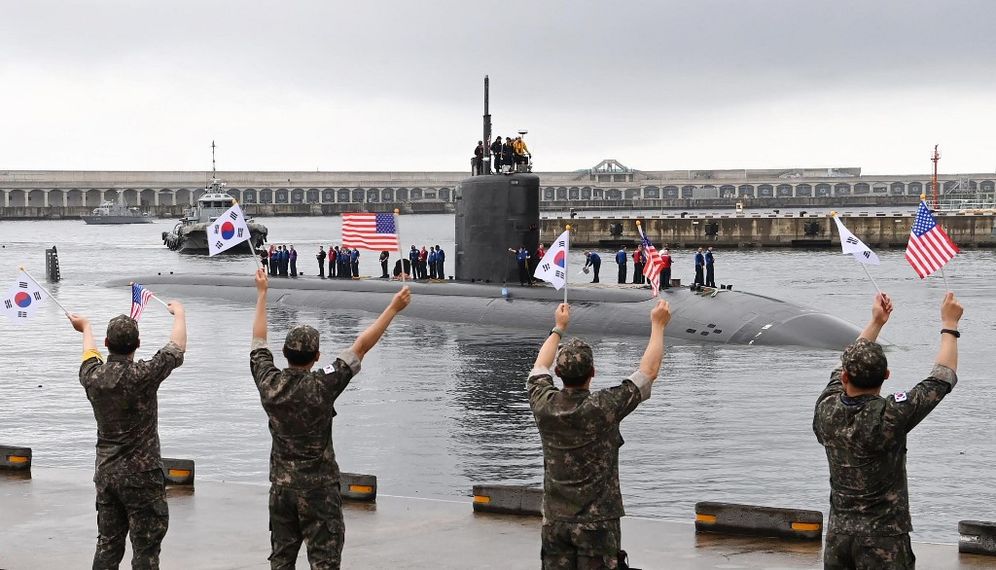 This handout photo taken on July 24, 2023 and provided by the South Korean Defence Ministry shows the USS Annapolis, a US nuclear-powered submarine, arriving as South Korean soldiers wave flags at a naval base in South Korea's southern island of Jeju.
