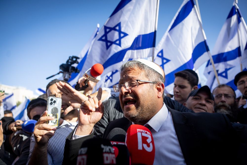 Itamar Ben-Gvir and hundreds of right-wing activists waving the Israeli flag attend a march through Jerusalem's Old City, April 20, 2022.