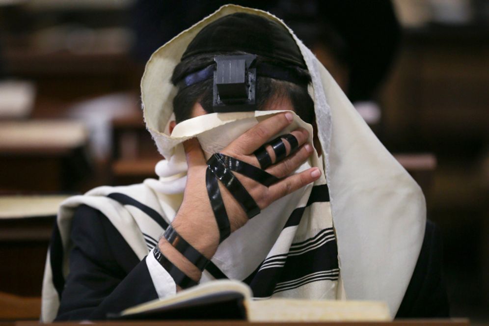 A young ultra orthodox Jewish men studying at a yeshiva (Jewish seminary) in Jerusalem, seen wearing tefilin and a prayer shawls during morning prayers.