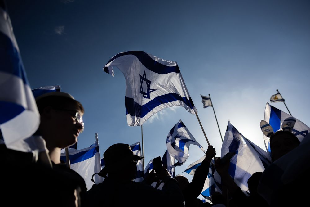 Des centaines de militants de droite brandissant le drapeau israélien lors d'une marche dans la vieille ville de Jérusalem, le 20 avril 2022