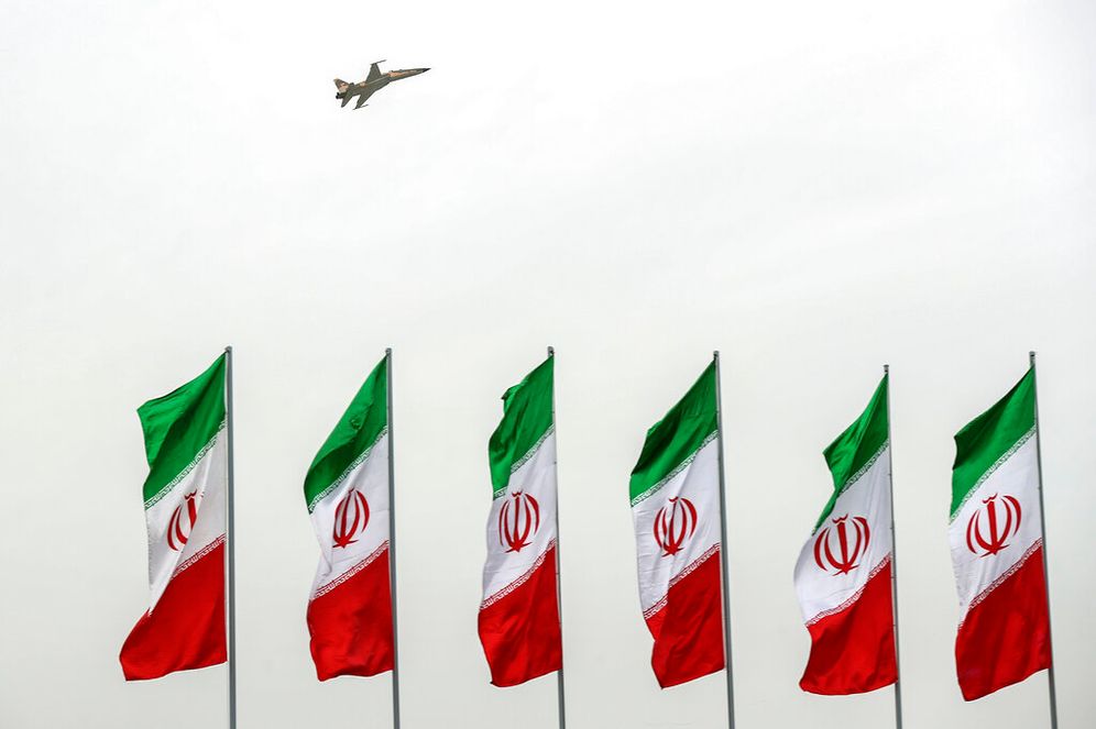 A fighter jet flies over Iranian flags in Tehran, Iran.