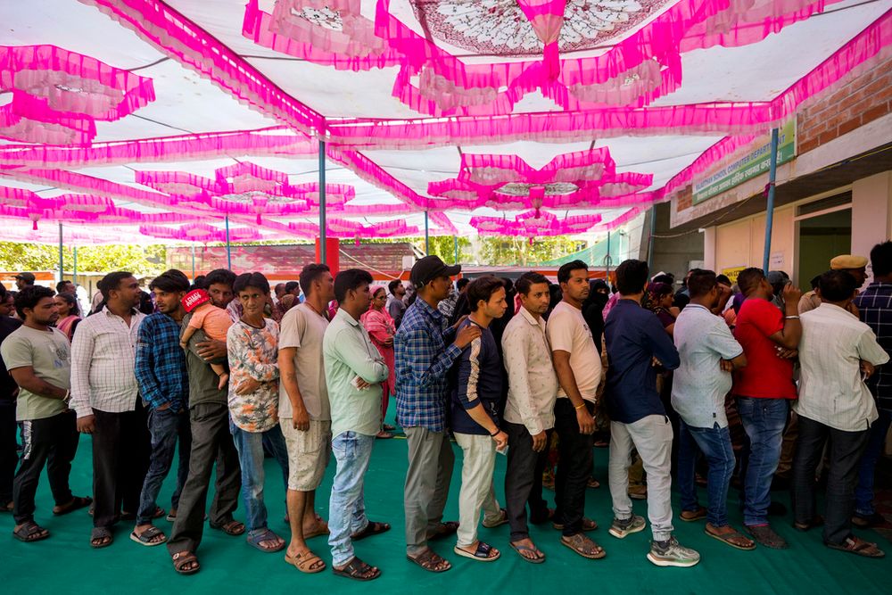 People stand in queue to cast their votes during the third phase of general elections, in Ahmedabad, India.