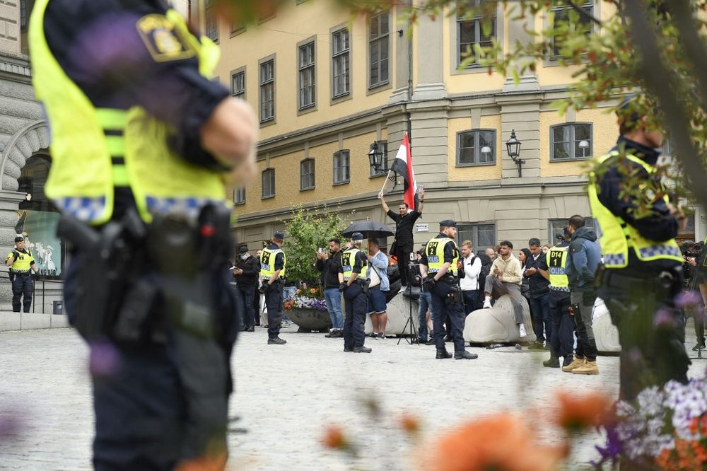 Policemen stand next to demonstrators in Stockholm, Sweden.