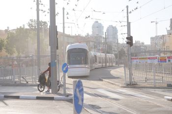 A Tel Aviv Light Rail Red Line train approaching an at-grade crossing during testing in Bat Yam, Israel.