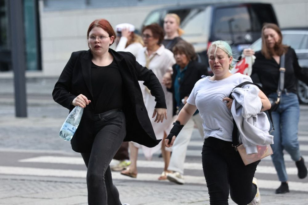 Customers flee from a shopping center after gunfire killed several people in Copenhagen, Denmark, July 3, 2022.