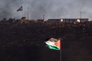 A Palestinian flag flies in the town of Beita, the West Bank city of Nablus, opposite the recently-evacuated Israeli settler outpost of Eviatar on July 6, 2021.