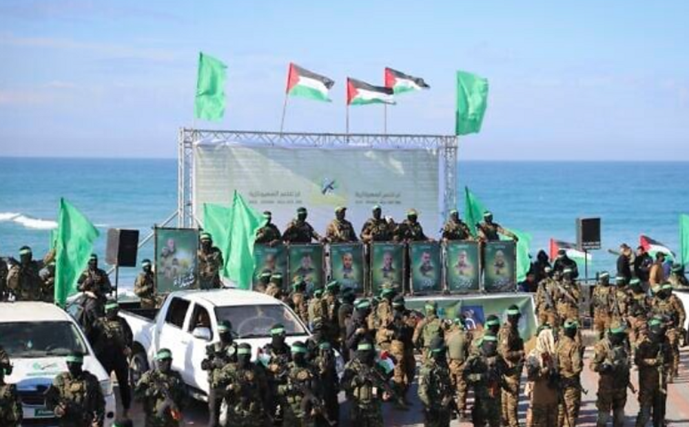 Des terroristes du Hamas se déploient sur l'estrade avant la remise de l'otage américano-israélien Keith Siegel, 65 ans, à la Croix-Rouge à Gaza-ville, samedi 1er février 2025. 

