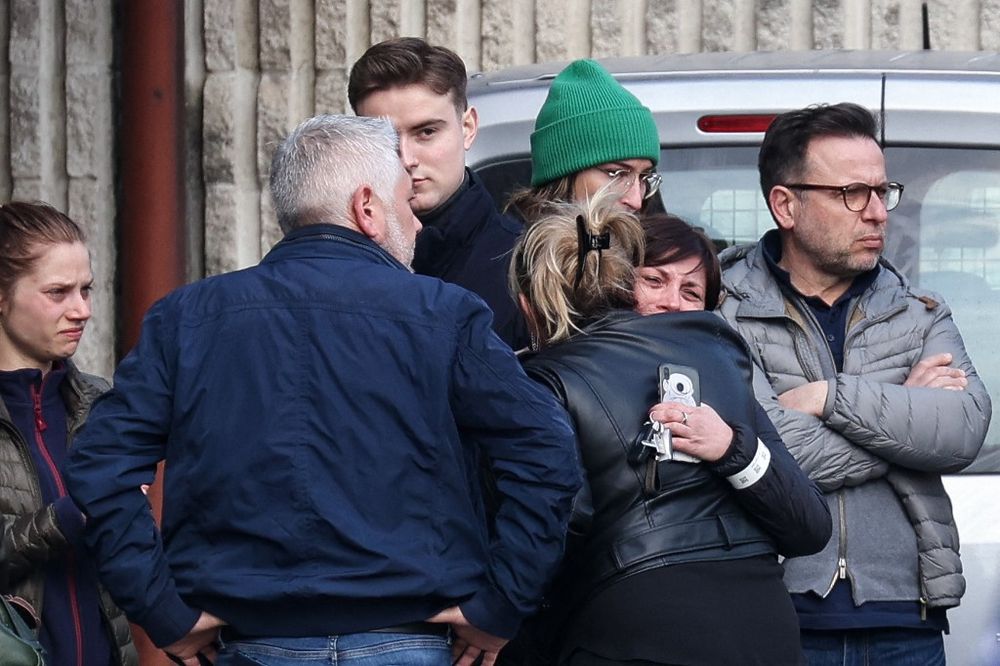 People gather near a gymnasium where witnesses and relatives of victims are received near the site where a car crashed into a crowd of carnival-goers in Strepy-Bracquegnies, Belgium, on March 20, 2022.