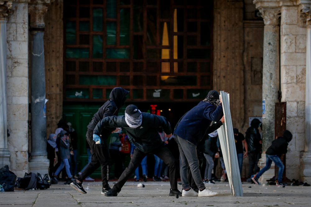 Des émeutiers palestiniens lancent des pierres contre les forces de sécurité israéliennes lors d'affrontements sur le mont du Temple dans la vieille ville de Jérusalem, le 22 avril 2022