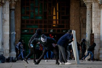 Des émeutiers palestiniens lancent des pierres contre les forces de sécurité israéliennes lors d'affrontements sur le mont du Temple dans la vieille ville de Jérusalem, le 22 avril 2022