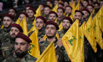 Des terroristes du Hezbollah tiennent les drapeaux de leur groupe alors qu'ils défilent lors d'un rassemblement à l'occasion de la Journée de Jérusalem dans la banlieue sud de Beyrouth, au Liban, le 14 avril 2023.