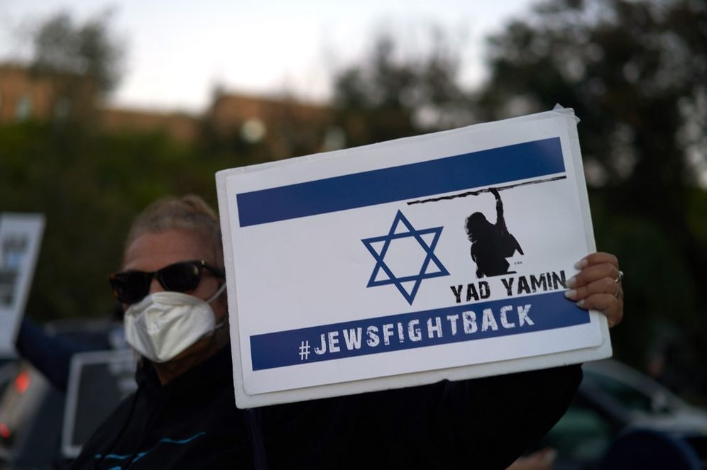 A woman holds a Jews Fight Back sign as members of the Sephardic Jewish Community in Brooklyn, New York, on October 8, 2020.