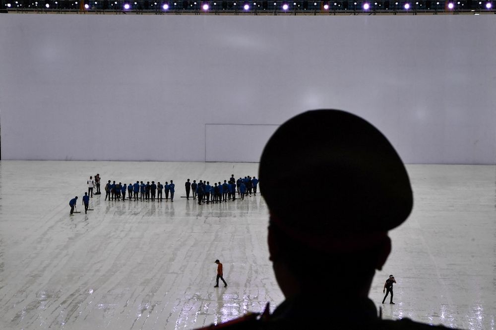 Volunteers wipe the floor as a security guard looks on before the opening ceremony of the 31st Southeast Asian Games at the My Dinh National Stadium in Hanoi, Vietnam, on May 12, 2022.