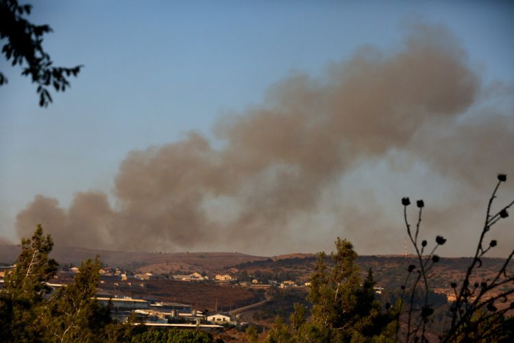 De la fumée s'élève d'un incendie causé par une roquette tirée du Liban près de Moshav Avivim à la frontière avec le Liban, dans le nord d'Israël