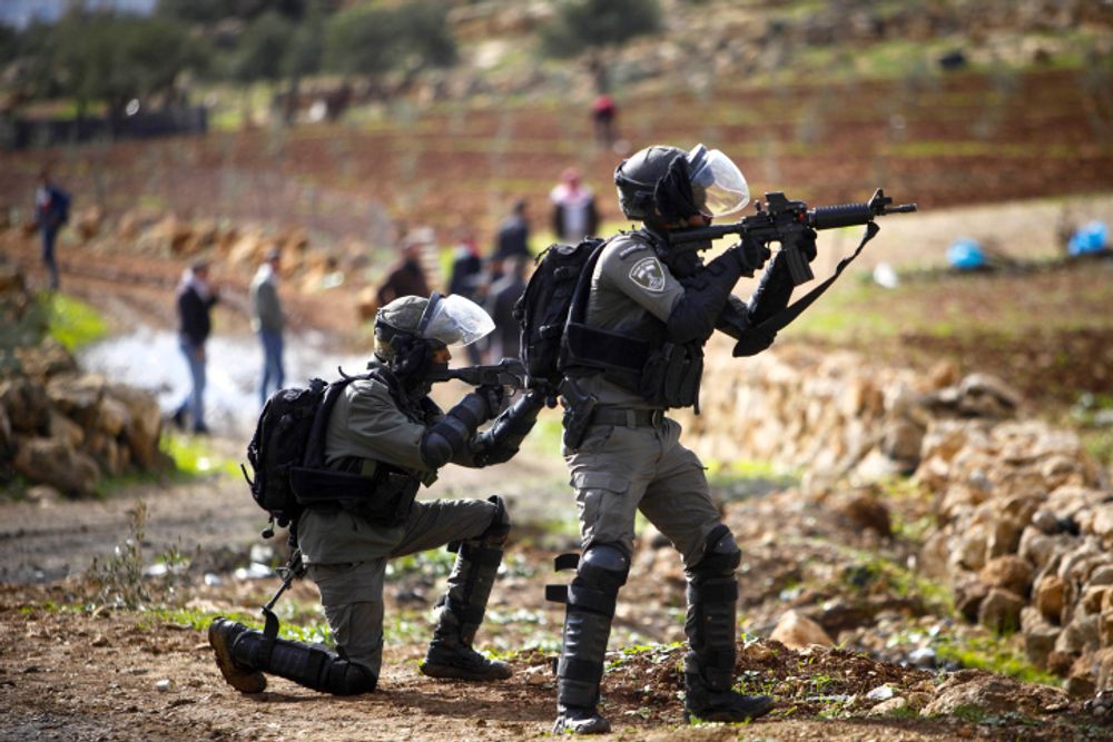 Palestinians clash with Israeli security forces during a protest in the village of Beit Dajan, near the West Bank city of Nablus, on December 24, 2021.