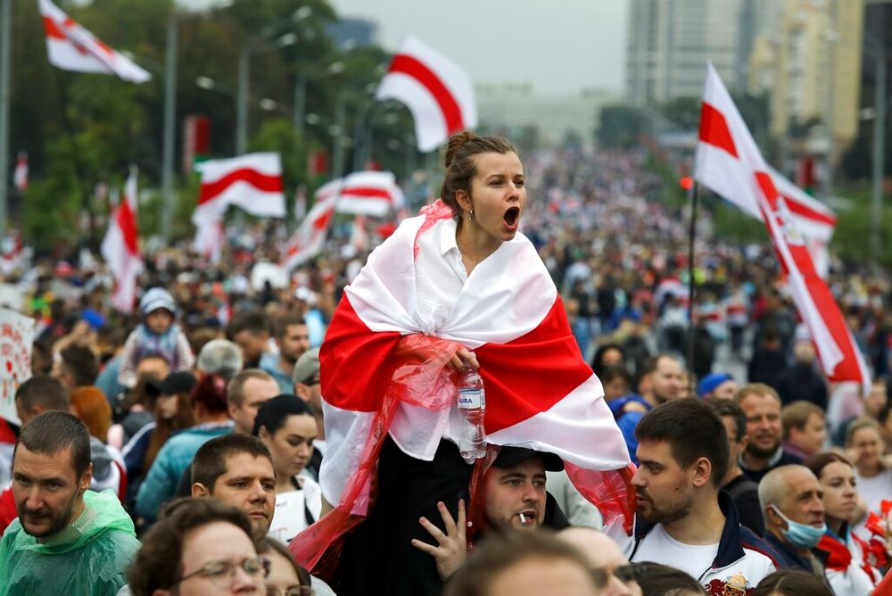 A woman covers herself with an opposition flag during a protest in Minsk, Belarus.
