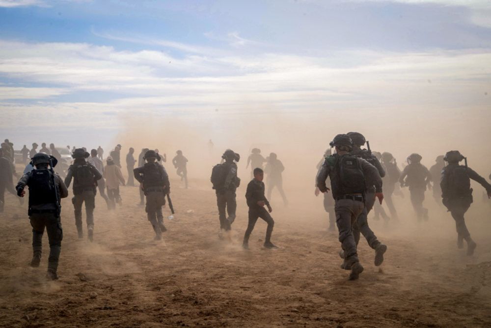 Des policiers israéliens affrontent des Bédouins lors d'une manifestation contre la plantation d'arbres par le Fonds national juif, près du village bédouin d'al-Atrash dans le désert du Néguev, le 12 janvier 2022.