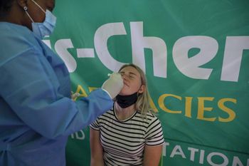 A healthcare worker conducts a polymerase chain reaction (PCR) Covid 19 test on a traveler at OR Tambo International Airport in Johannesburg, South Africa, on November 27, 2021.