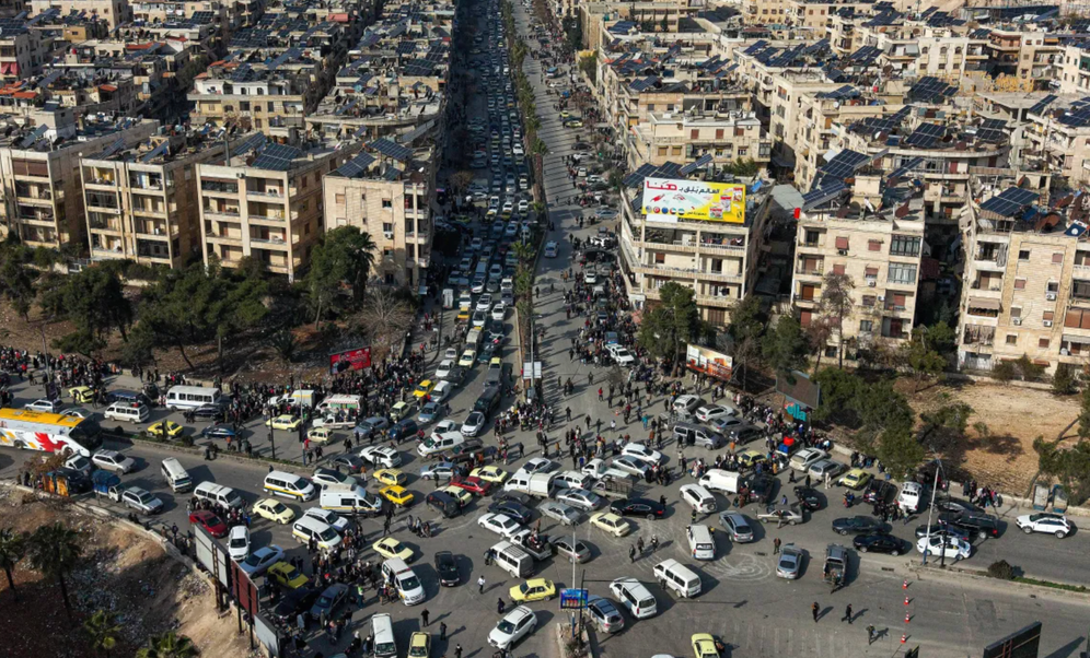 An aerial view shows Syrian residents in vehicles, queuing to flee the Sheikh Maqsoud and Achrafieh districts after clashes broke out Tuesday between Syrian government forces and Kurdish fighters in a disputed area of ​​the northern Syrian city of Aleppo, Wednesday, January 7, 2026.