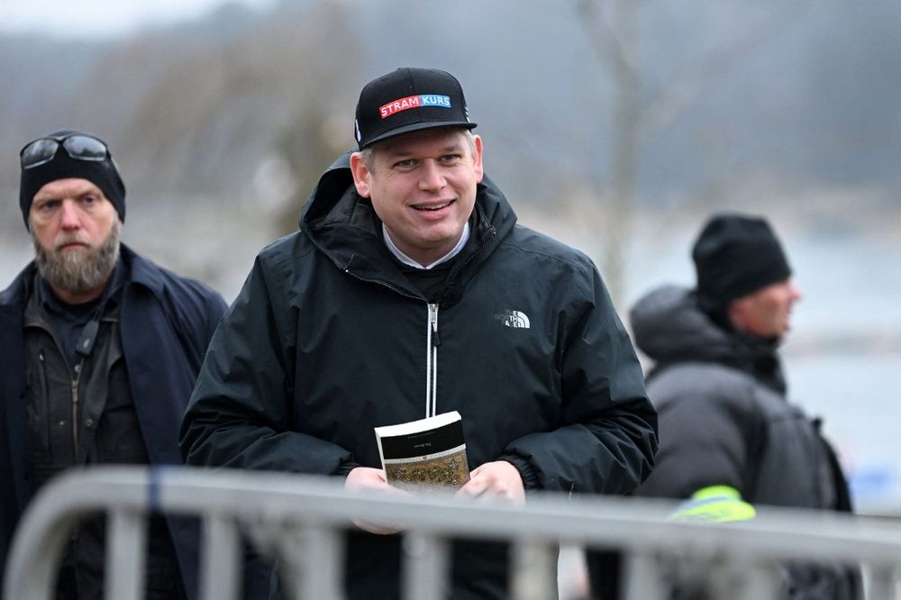 Swedish-Danish extremist Rasmus Paludan holds an edition of the Quran during a protest outside the Turkish embassy in Stockholm, Sweden.