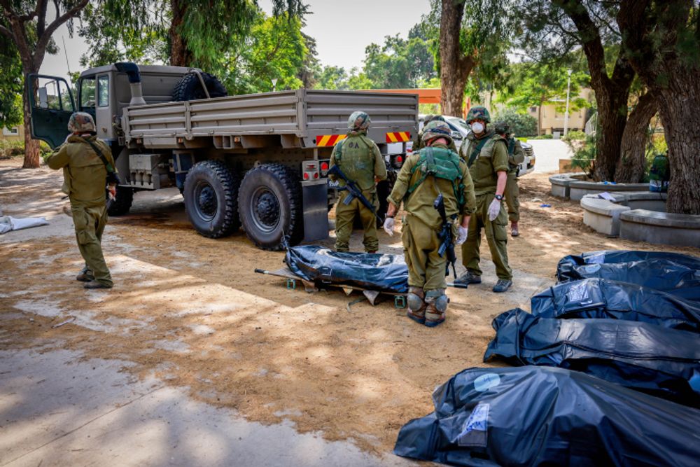 Israeli soldiers remove bodies in Kibbutz Kfar Aza, near the border with Gaza, in southern Israel.