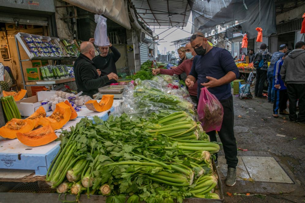People shop at a market in the central town of Ramle, Israel, on December 31, 2021.
