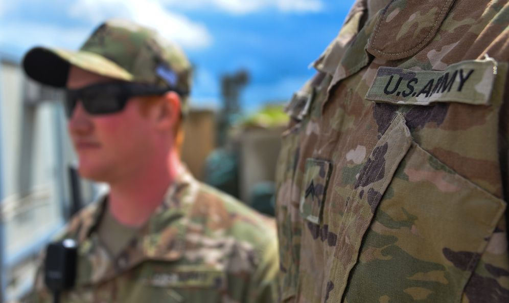 FILE - US troops from the Combined Joint Task Force stand at a former presidential palace turned into an Iraqi base in the northern Iraqi province of Nineveh during a handover ceremony to Iraqi forces, on March 30, 2020.