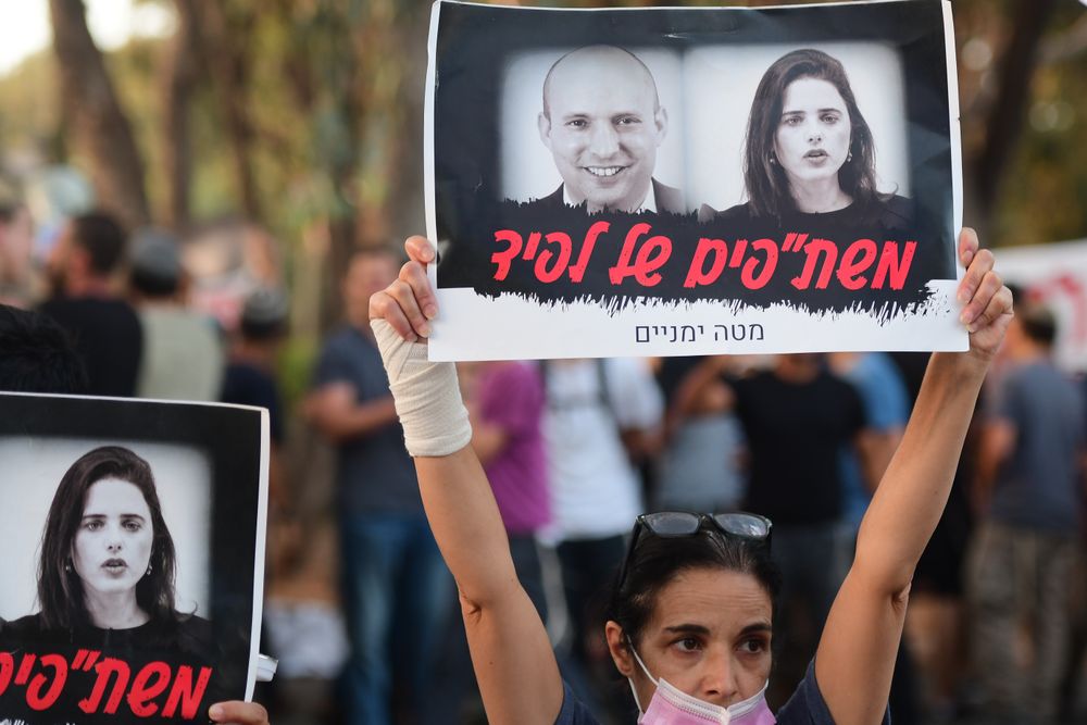 أنصار يتظاهرون أمام منزل أييليت شاكيد في تل أبيب في 30 مايو 2021 ، رافعين لافتة "عملاء لبيد"