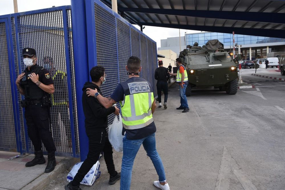 Spanish policemen control migrants crossing the border back to Morocco at the Spanish enclave of Ceuta on May 20, 2021.