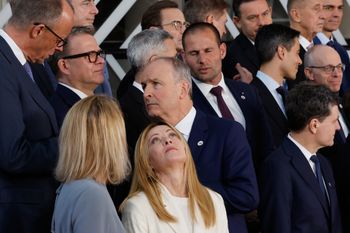 رئيسة الوزراء الإيطالية جورجيا ميلوني، الخامسة من اليسار، تنظر إلى الوراء نحو المستشار الألماني فريدريش ميرز، على اليسار، خلال صورة جماعية في قمة الاتحاد الأوروبي في بروكسل، الخميس 19 مارس 2026.