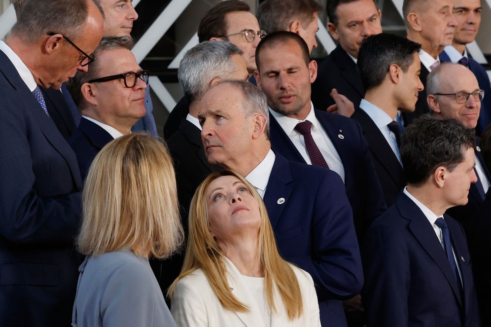 AP Photo/Geert Vanden Wijngaert رئيسة الوزراء الإيطالية جورجيا ميلوني، الخامسة من اليسار، تنظر إلى الوراء نحو المستشار الألماني فريدريش ميرز، على اليسار، خلال صورة جماعية في قمة الاتحاد الأوروبي في بروكسل، الخميس 19 مارس 2026.