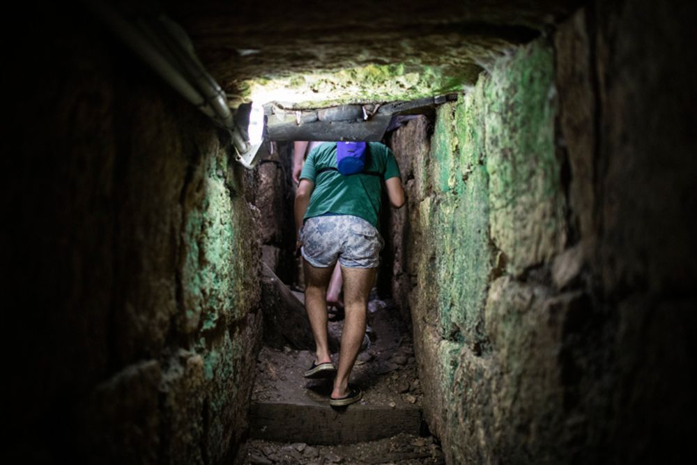 Turistas caminham pelo túnel de drenagem principal que leva da Piscina Siloam ao Parque Arqueológico Davidson's Center, no Parque Nacional da Cidade de David, em Jerusalém, em 22 de julho de 2019.