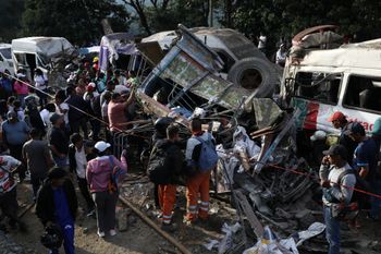People gather around vehicles damaged in an attack on the Pan-American Highway in Cajibio, Colombia, Saturday, April 25, 2026, that killed at least a dozen people and authorities blamed on dissident groups of the former FARC rebels