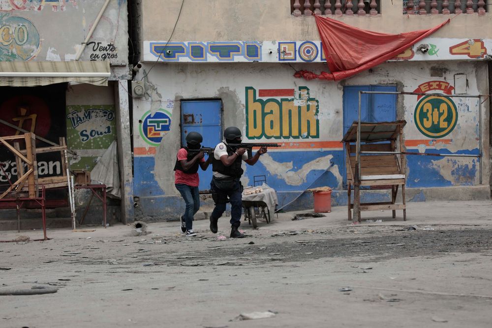 Police officers take cover during an anti-gang operation in the Portail neighborhood of Port-au-Prince, Haiti.