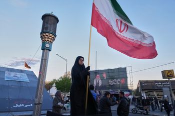 امرأة تحمل العلم الإيراني في وسط طهران، 06.04.2026