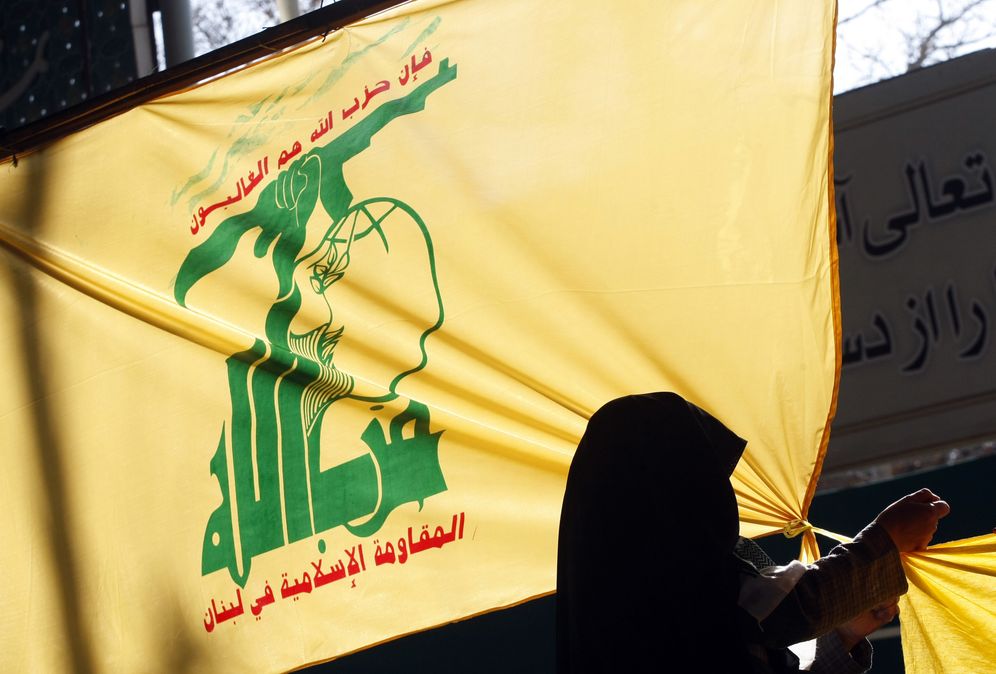Illustration - Une femme iranienne suspend un drapeau du Hezbollah libanais à l'extérieur de l'Université de Téhéran, le 2 février 2009