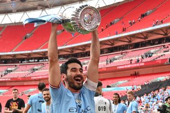 Manchester City's German midfielder Ilkay Gundogan celebrates with the trophy.