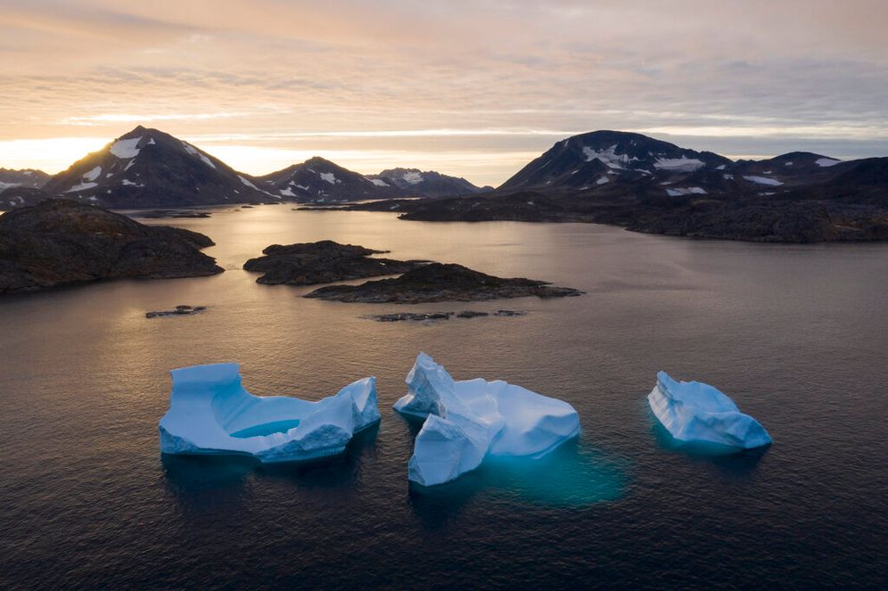 Large icebergs float away as the sun rises near Kulusuk, Greenland, on August 16, 2019.