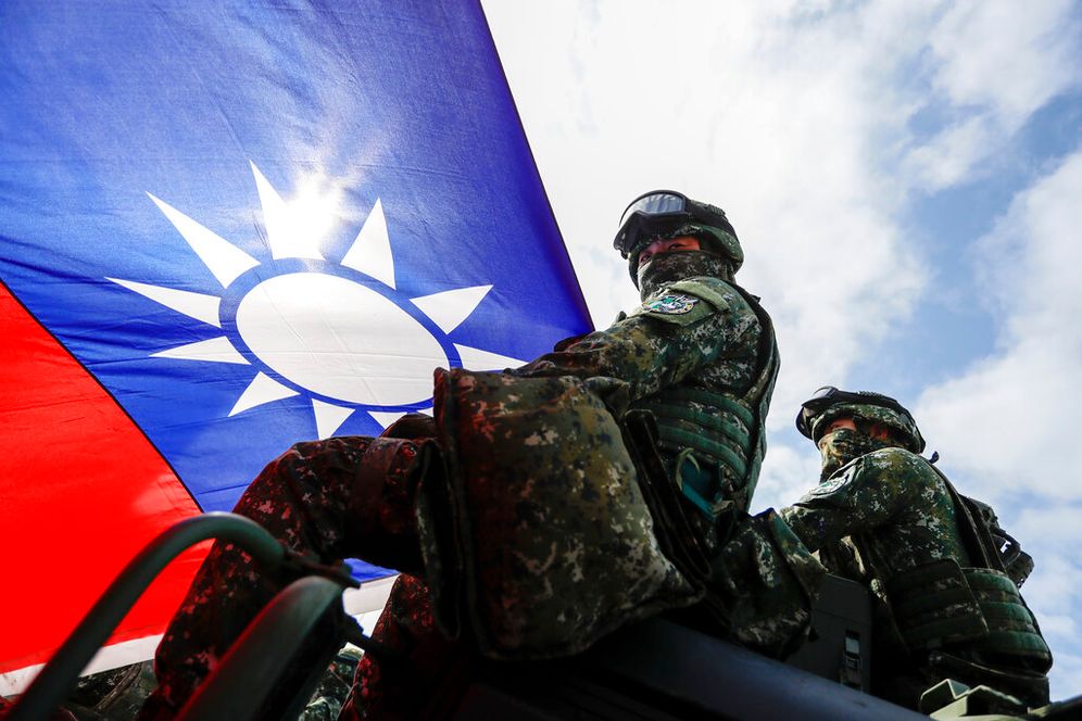 Soldiers holding a Taiwanese flag during a preparedness enhancement drill simulating the defense against Beijing's military intrusions, in Kaohsiung City, Taiwan.